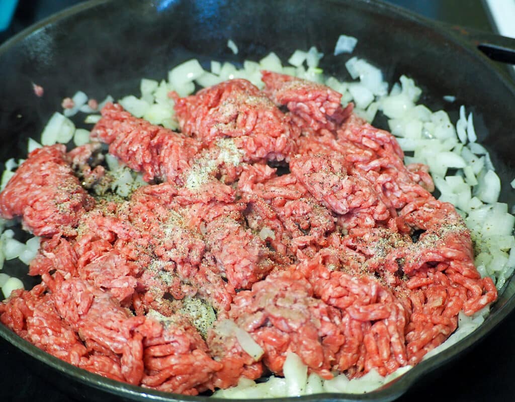 ground beef and onions cooking in fry pan