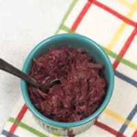 cooked red cabbage in blue bowl with spoon