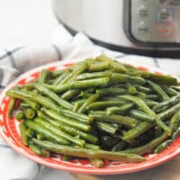 green beans on red plate in front of instant pot