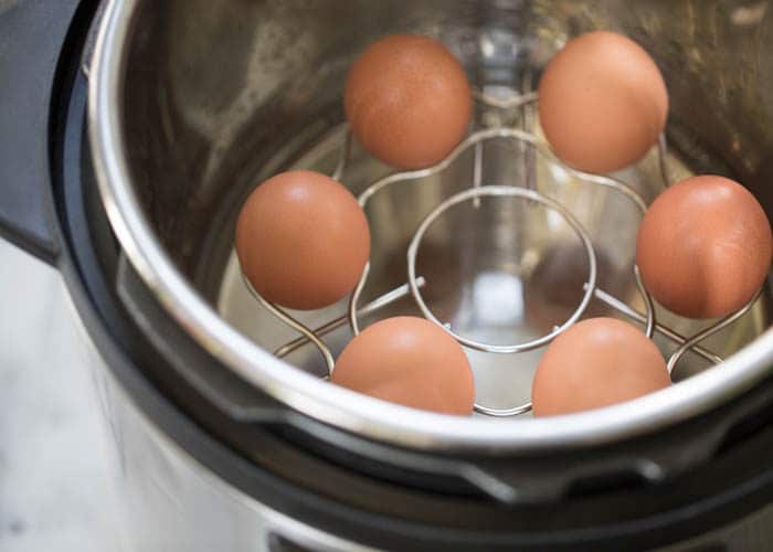 brown eggs in a holder trivet in an instant pot