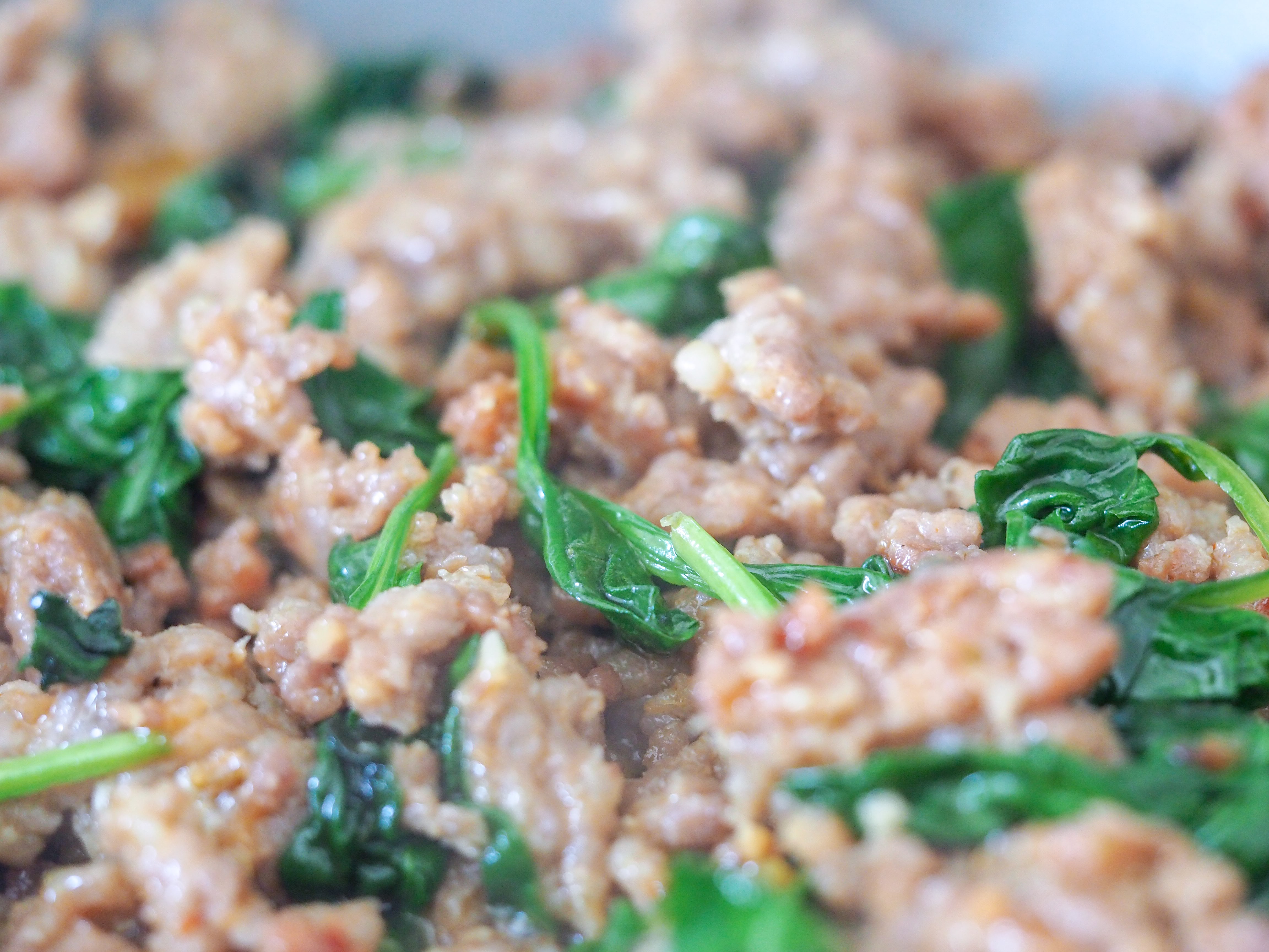 cooked italian sausage with spinach in a pan