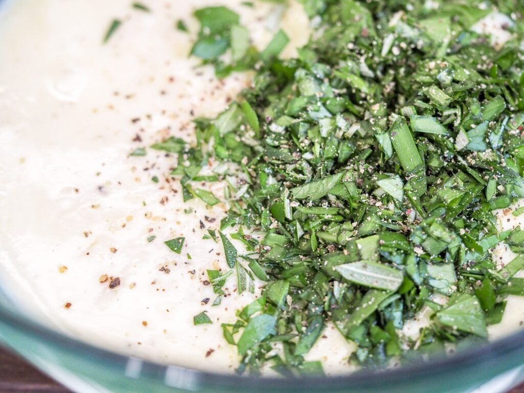 compound butter with herbs and pepper in a glass bowl