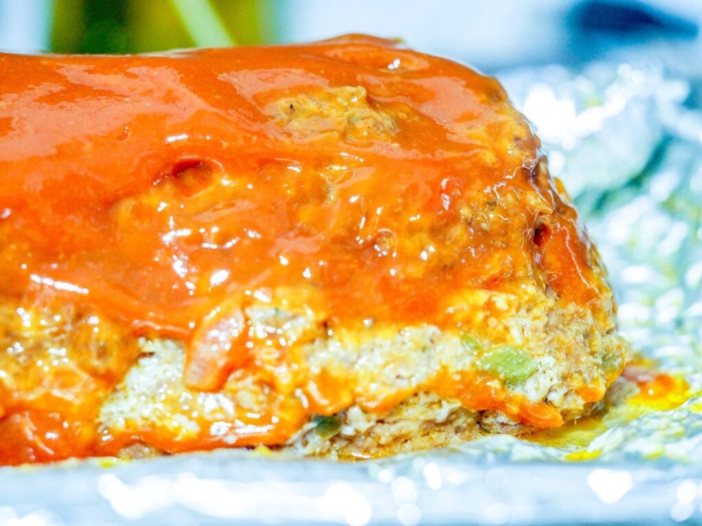 cooked meatloaf with ketchup topping on a baking sheet covered in foil