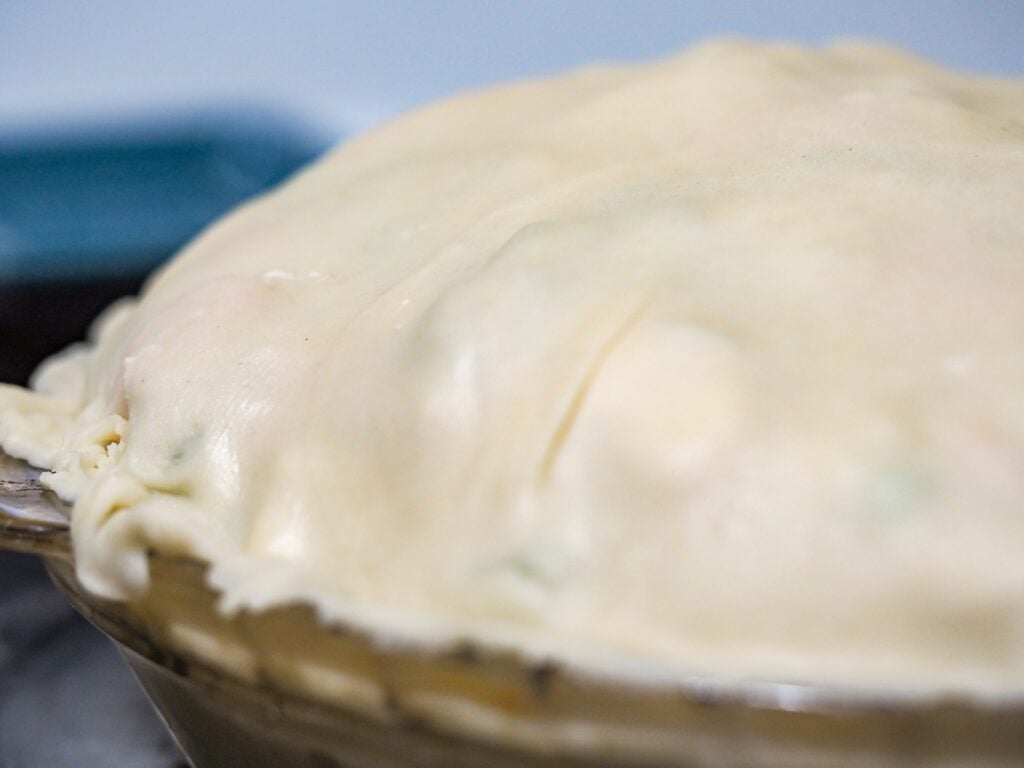 chicken pot pie unbaked in pie pan on top of stove