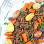 pot roast on platter with potatoes and carrots