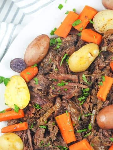 pot roast on platter with potatoes and carrots