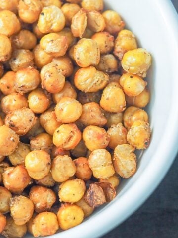 overhead close-up shot of air fried chickpeas in a white bowl on a rustic table