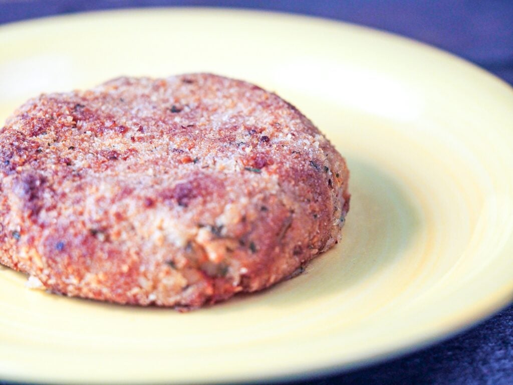 cooked salmon patty close-up on yellow plate