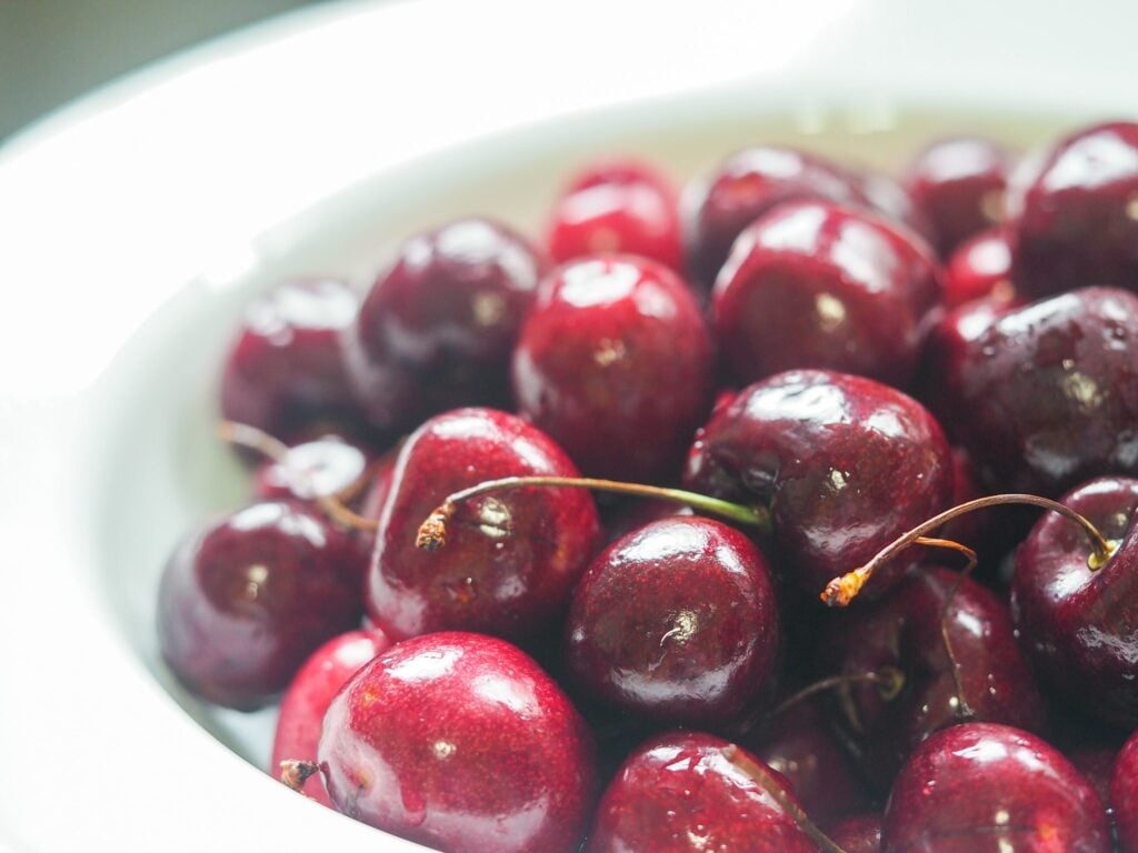 close up of fresh cherries in a colander