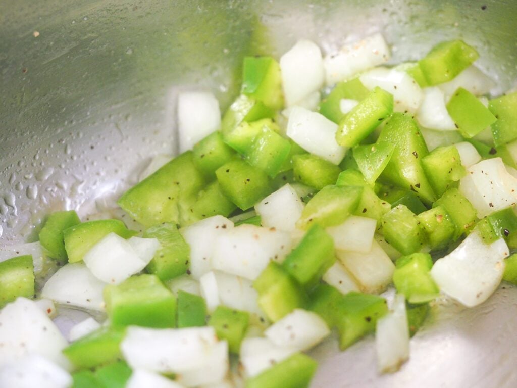 diced green peppers and onions sauteeing in instant pot (close view)