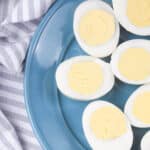 hard boiled eggs cut in half on blue plate