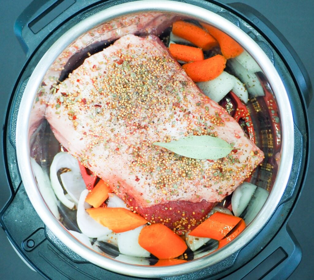 overhead shot of prepped corned beef cabbage prior to being cooked with carrots and onions.