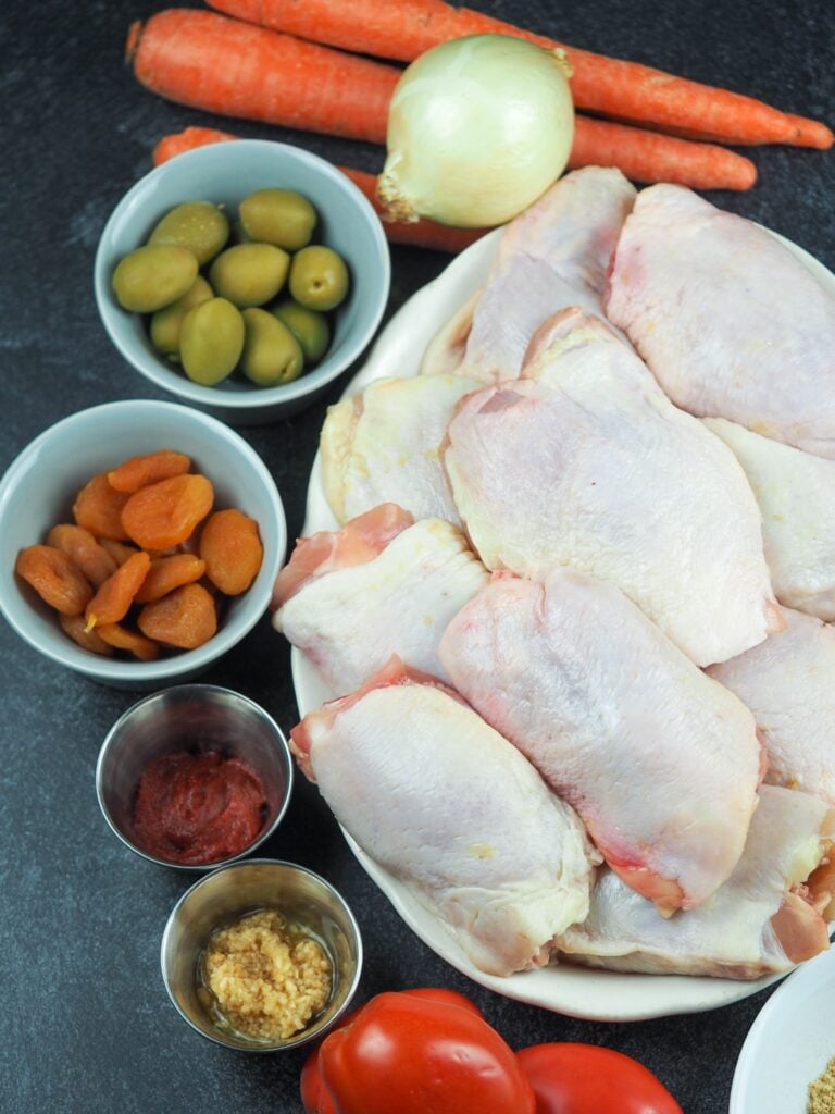 Chicken tagine ingredients laid out on black tabletop