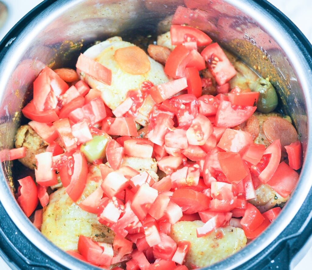 overhead view of chicken tagine ready to cook in the pressure cooker with all the ingredients layered