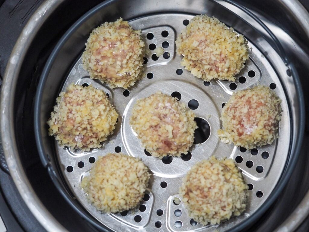 scotch quail eggs arranged in the instant pot air fryer for cooking