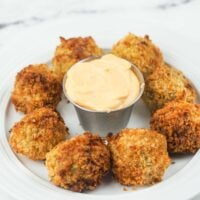 scotch eggs on white plate with dipping