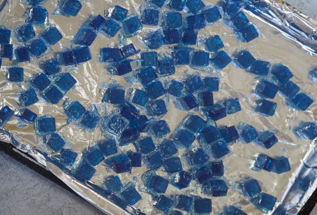 blue hard rock candy broken into pieces on baking sheet