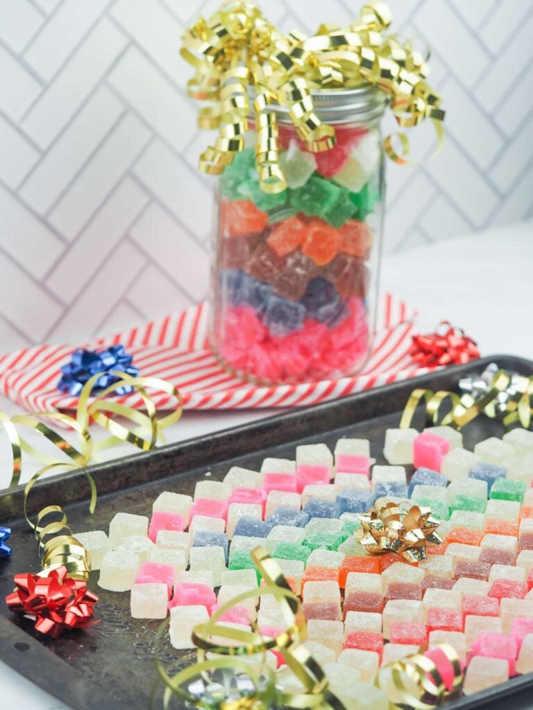 hard tack candy arranged on baking sheet with ribbons and jar of candy in background