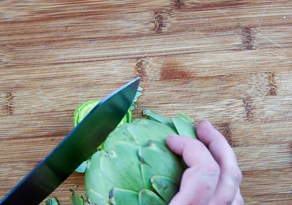 trimming the top of an artichoke