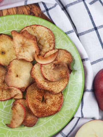 apple chips on green plate with red apples