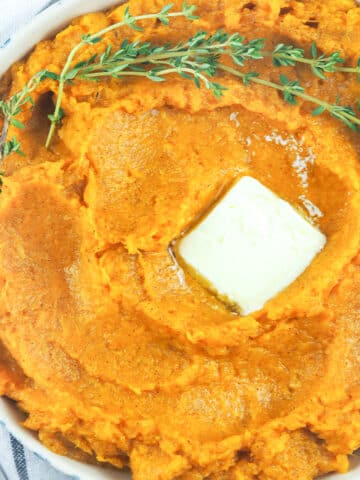 bowl of mashed sweet potatoes with pat of butter on top