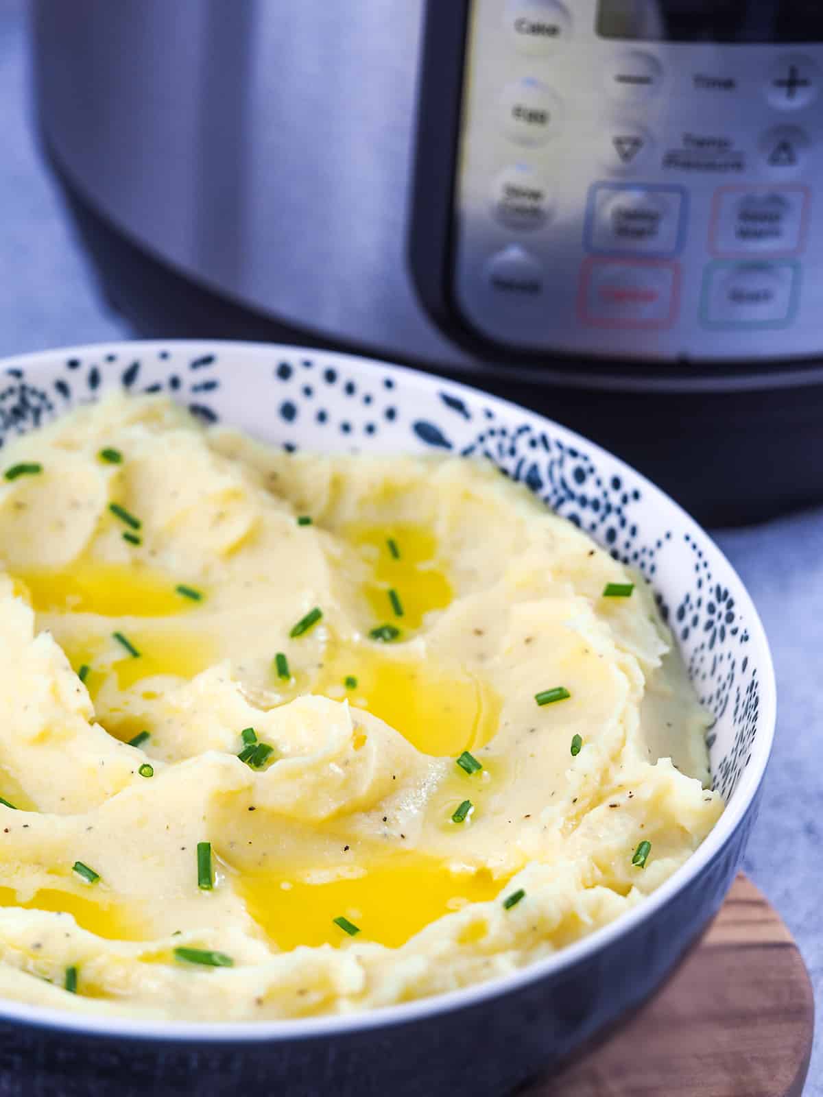 mashed potatoes in blue bowl with chives and butter