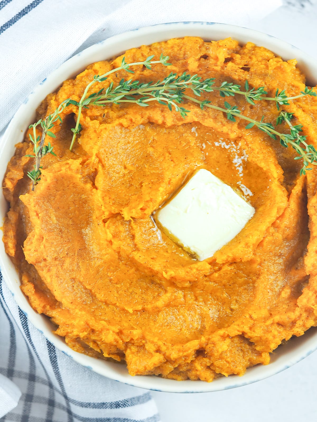 sweet potatoes in bowl with pat of butter