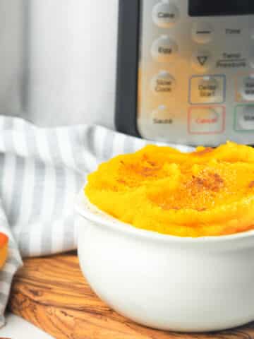 bowl of pumpkin dusted with cinnamon next to instant pot