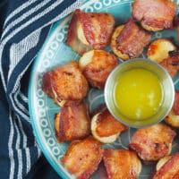 bacon wrapped scallops on plate with dipping butter