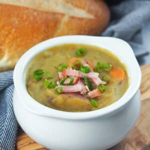 split pea soup in white crocked topped with diced ham