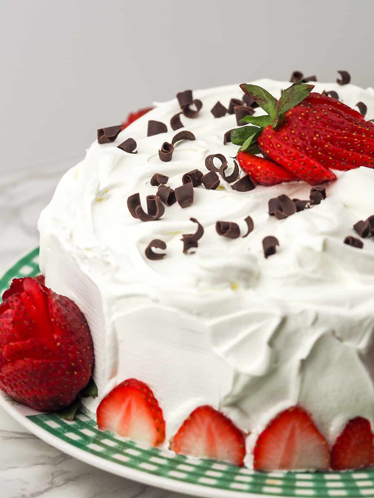 chocolate cake topped with strawberries and chocolate curls