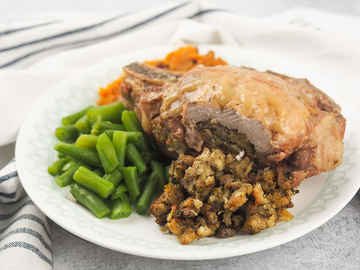 stuffed pork chops on plate with green beans