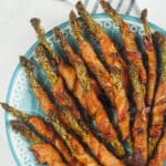asparagus wrapped with bacon on blue and white plate