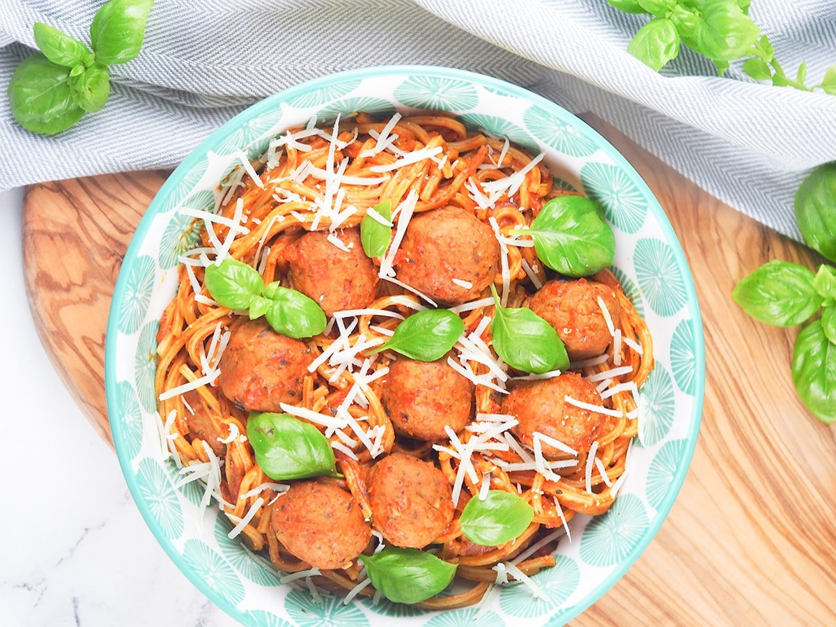 overhead meatballs and spaghetti with tomato sauce topped with basil