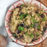 risotto in bowl on olive board with linen towel