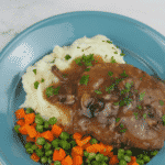 cube steak on blue plate with vegetables and potatoes with gravy