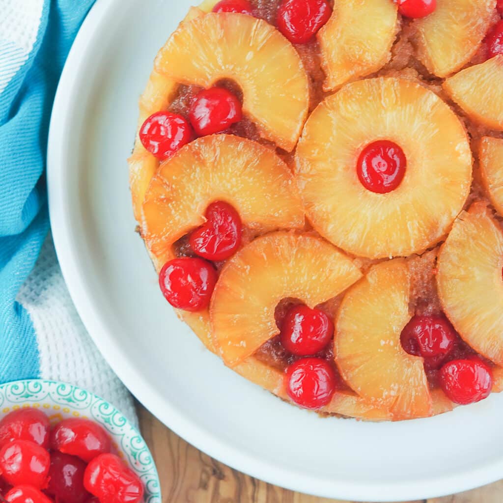 pineapple upside down cake with bowl of cherries