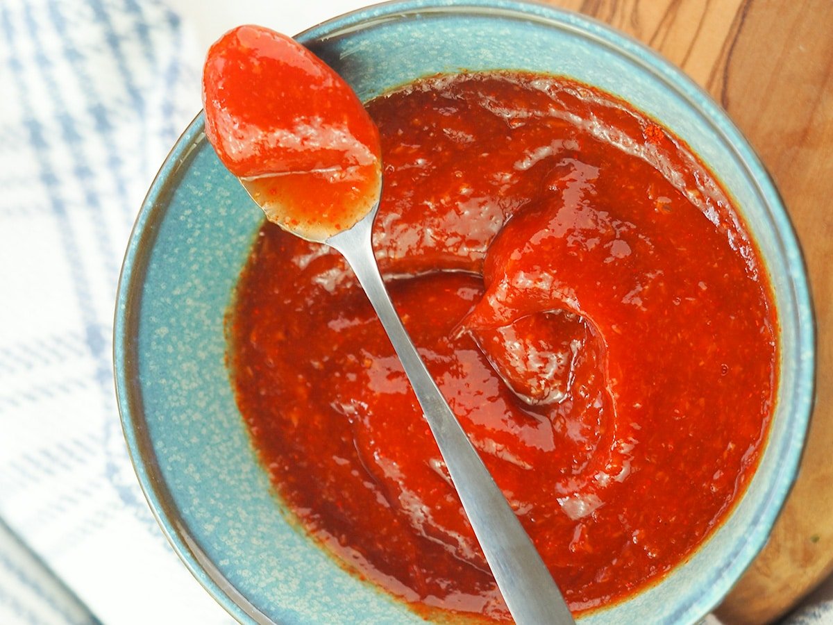 center set spicy ketchup in bowl with spoon resting on top