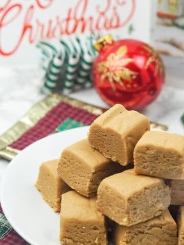 peanut butter fudge on white plate with ornaments