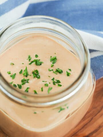 Comeback sauce in a pint mason jar with parsley sprinkled on top.